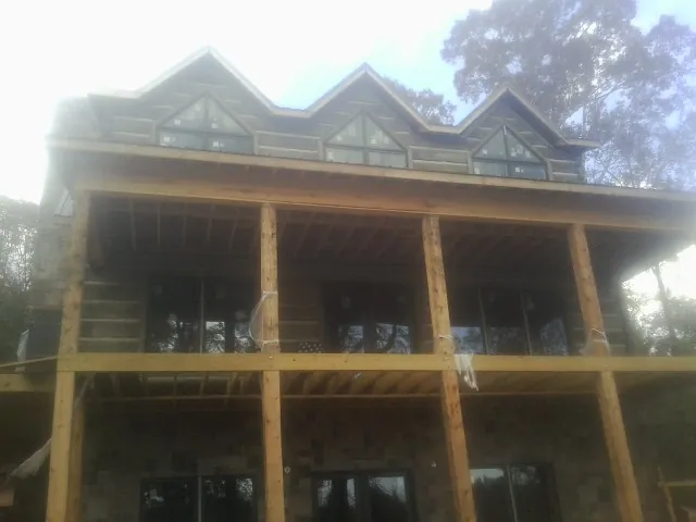 Dormers and porch framing on a large log home under construction — Roof Coating work by our crew in Fountain Valley