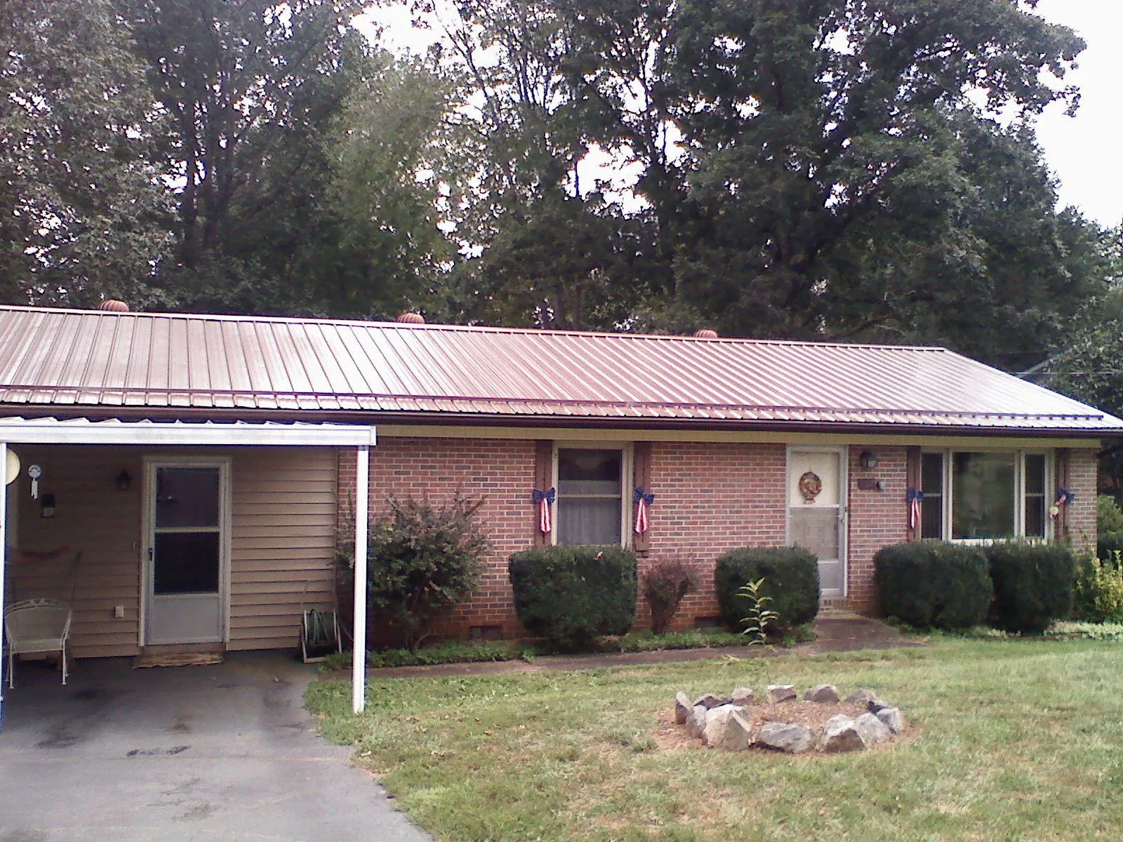 Bronze metal roof and carport on a brick ranch home — Roof Repair work by our crew in Fountain Valley